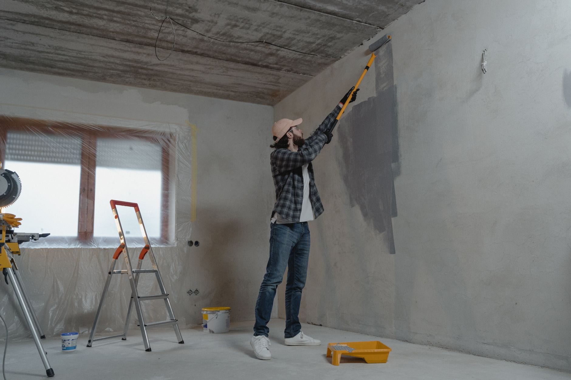 Tradesperson cutting in paint along a ceiling line
