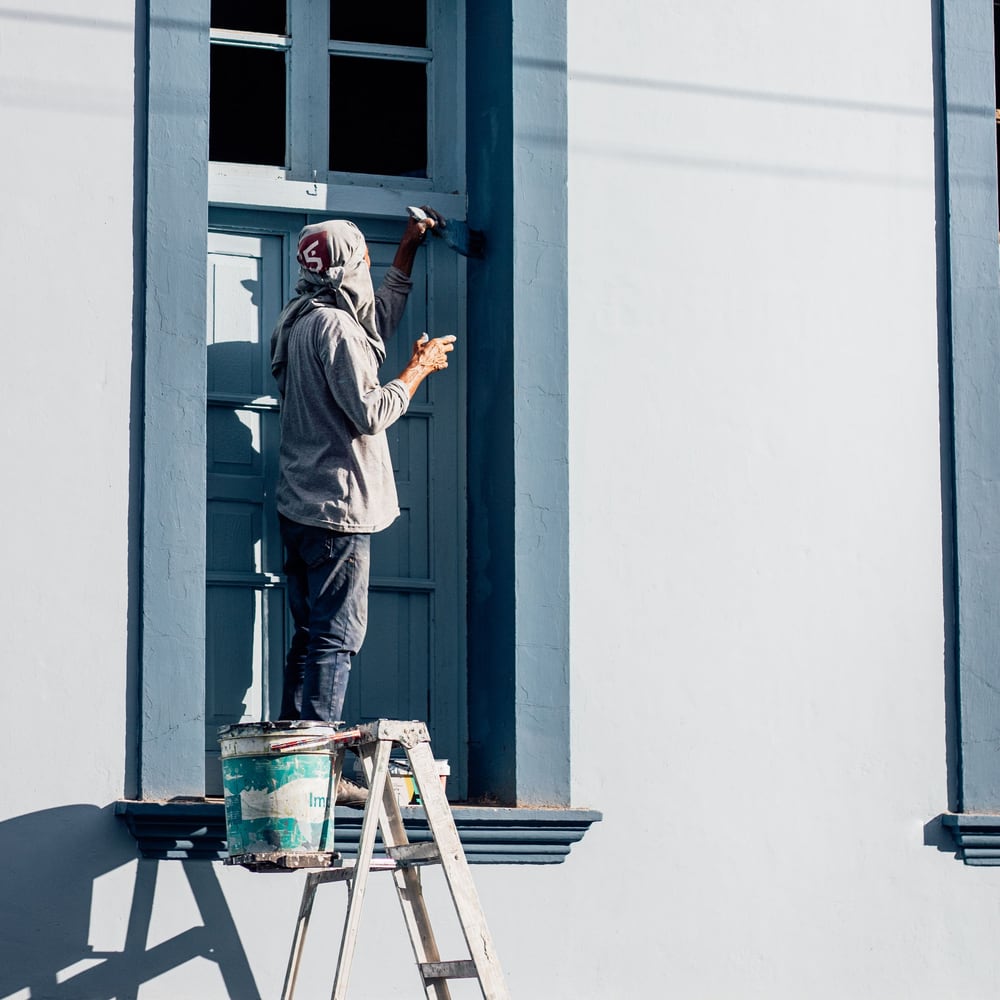 Paint roller and tools on an exterior job site