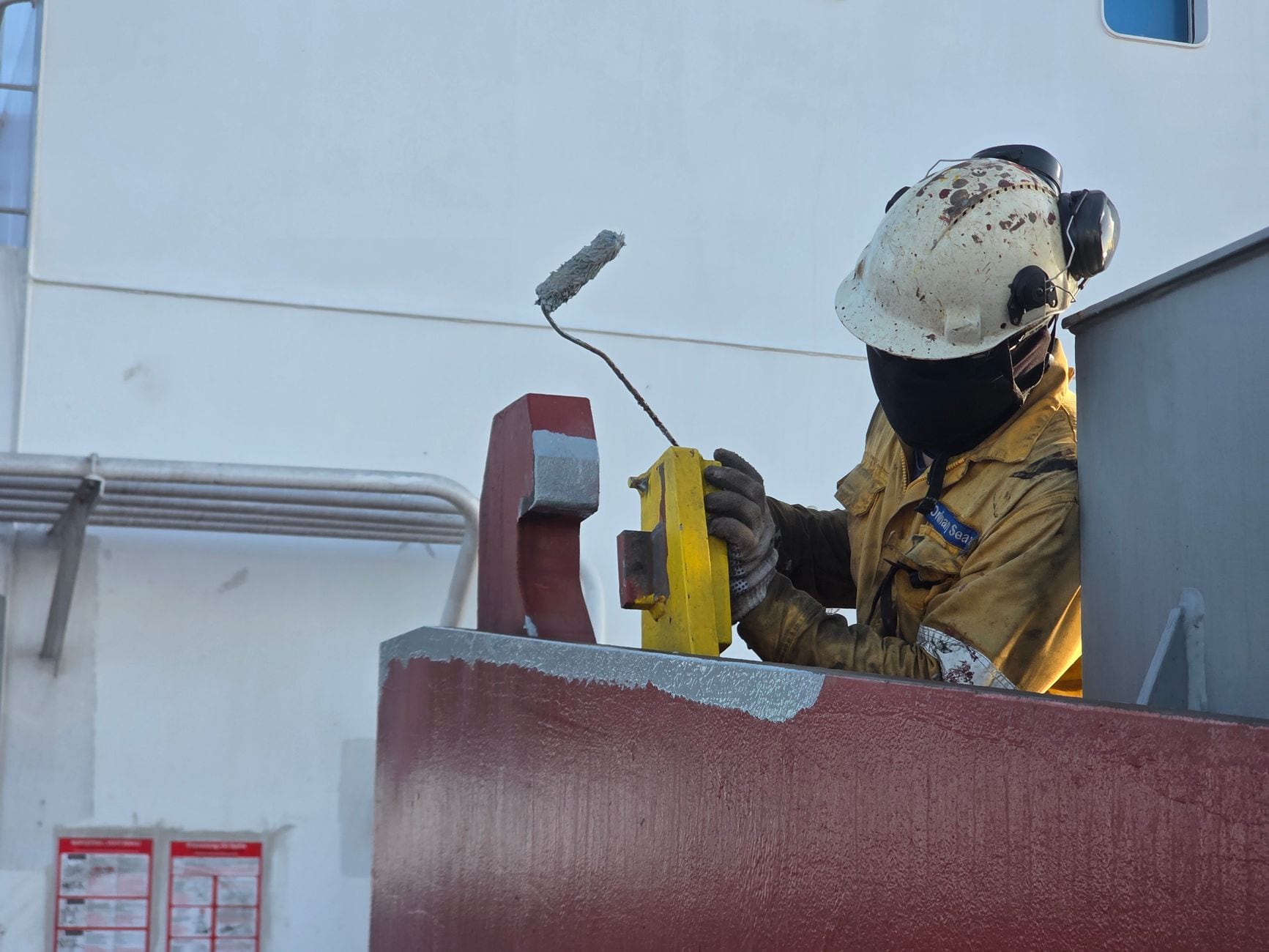Painter applying a second coat to a commercial shopfront.